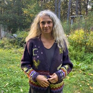 We are selling a 100% wool purple cardigan with intricate flower details.